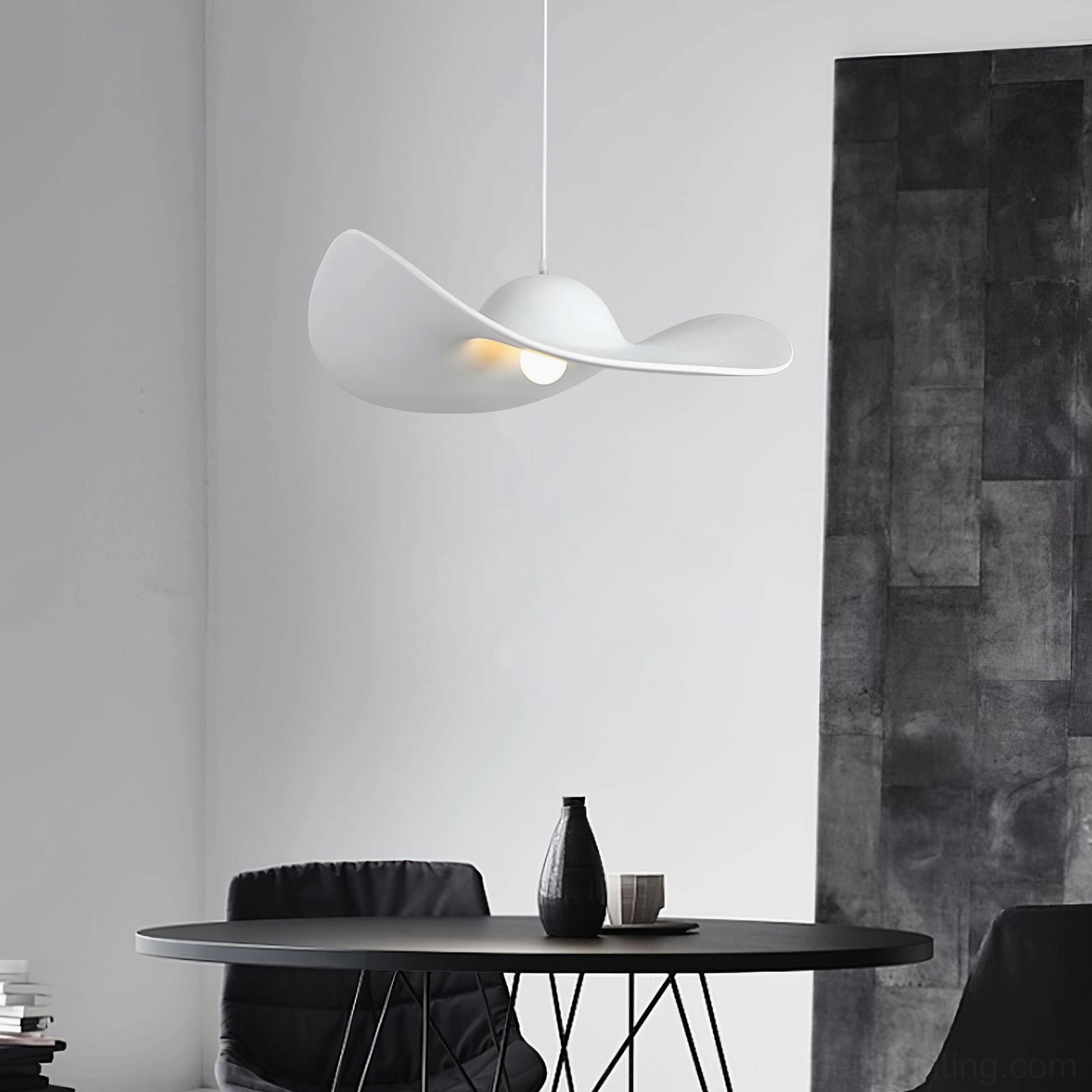 White straw hat pendant light hanging above minimalist black round dining table