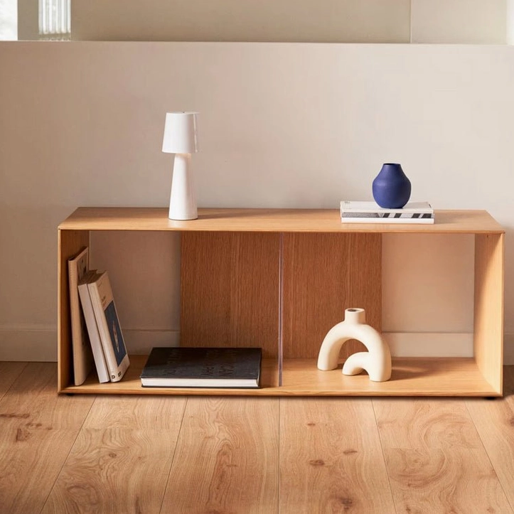 White cylindrical LED table lamp on wooden shelf in minimalist modern living space