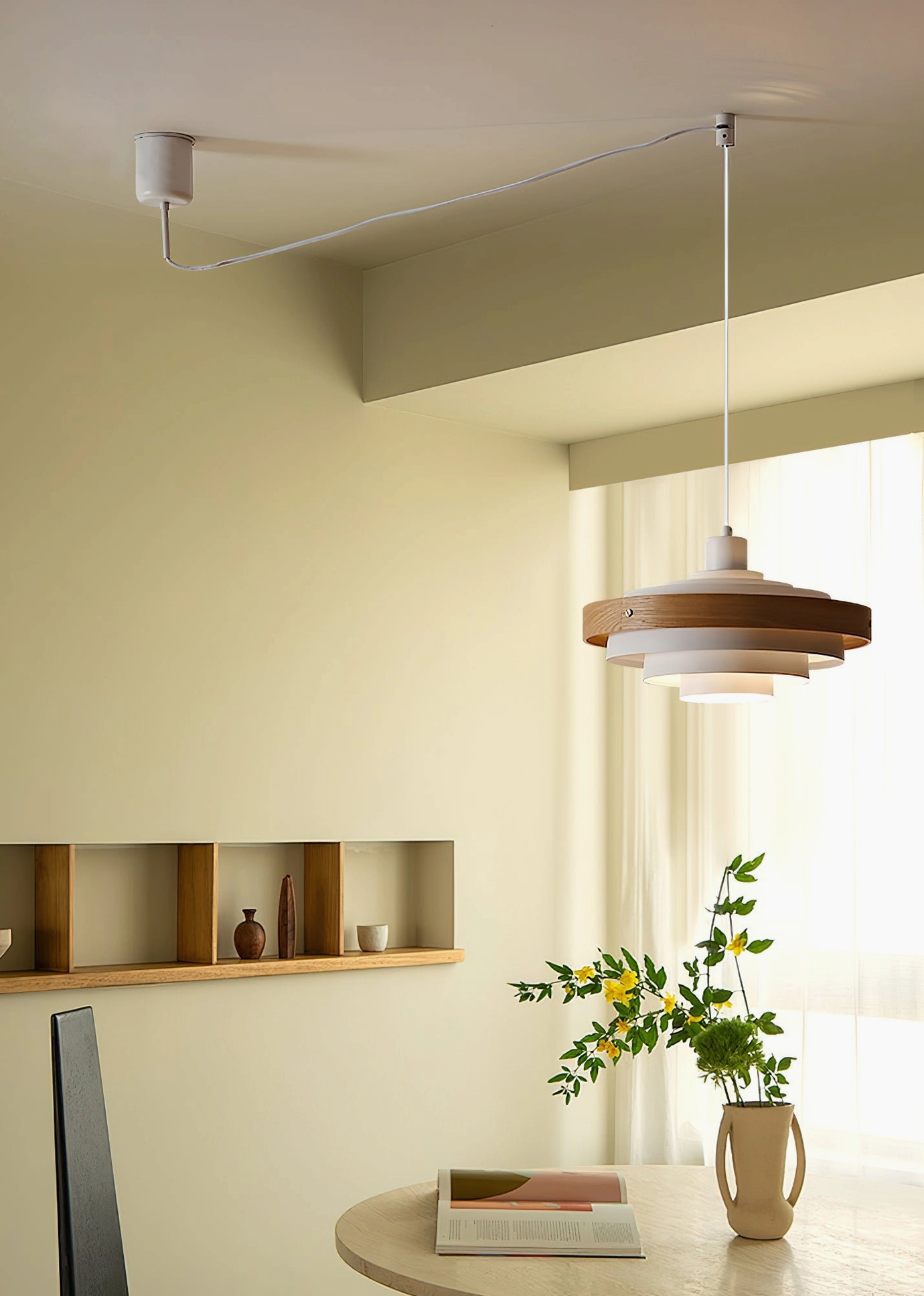 White swing arm pendant light with warm wood layered shade in minimalist dining nook