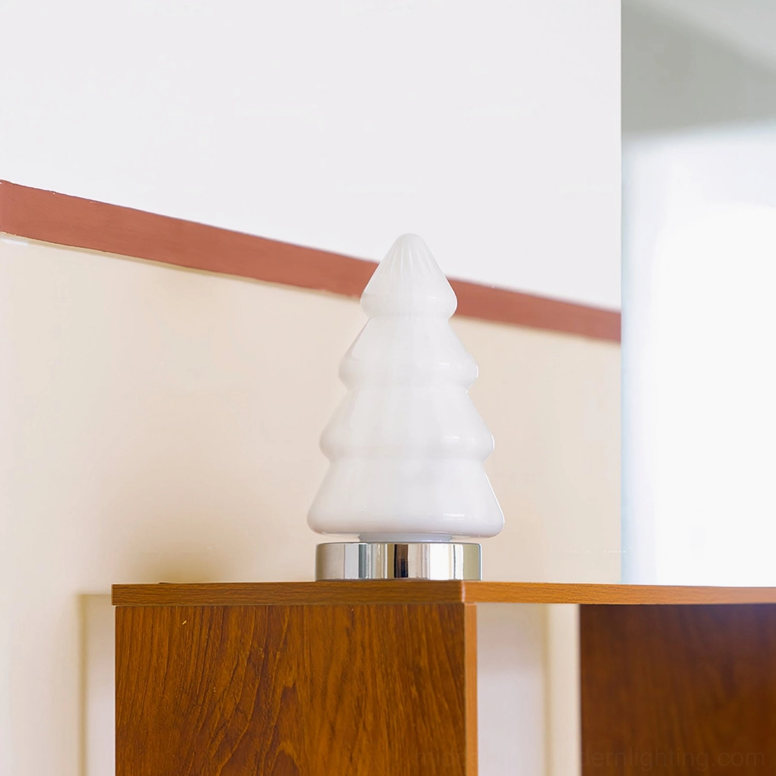 Close-up side view of white ceramic tree lamp showing ribbed texture detail and polished chrome base on wooden shelf