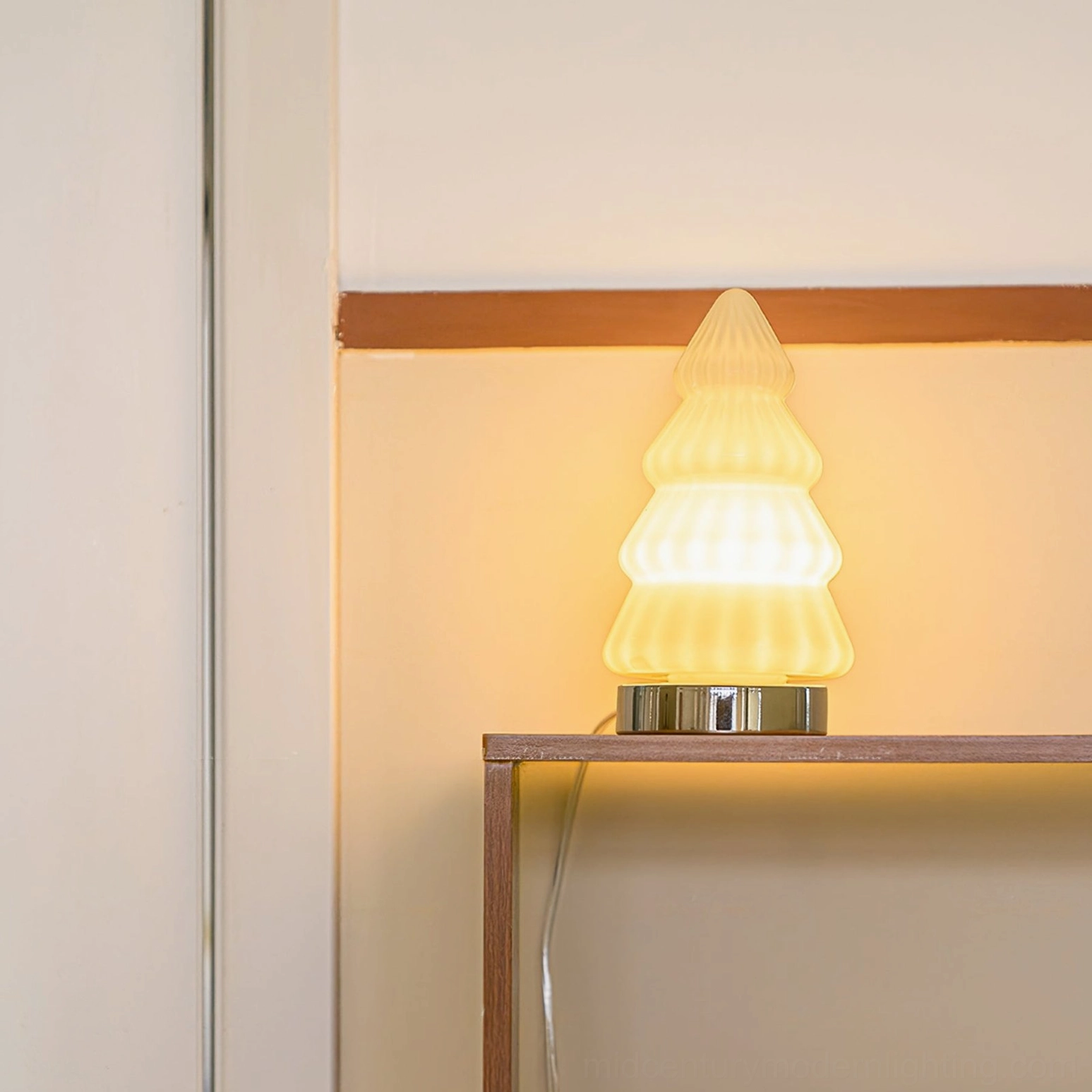 Illuminated white tree lamp emitting warm soft yellow light, creating ambient glow on indoor wall background