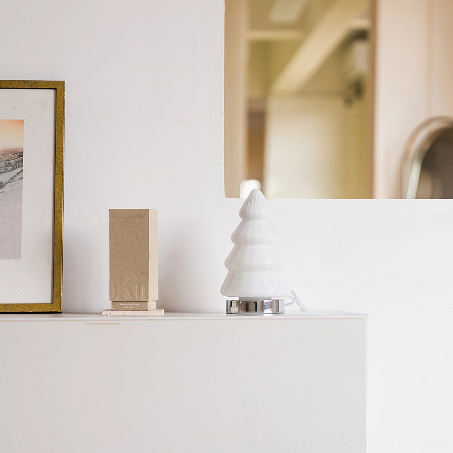 White tree table lamp displayed on neutral shelf with framed wall art and concrete decorative block modern aesthetic