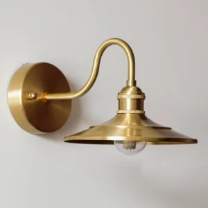 Detailed side profile of Whizzer brass wall light showing braided metal ring accent and polished gold construction