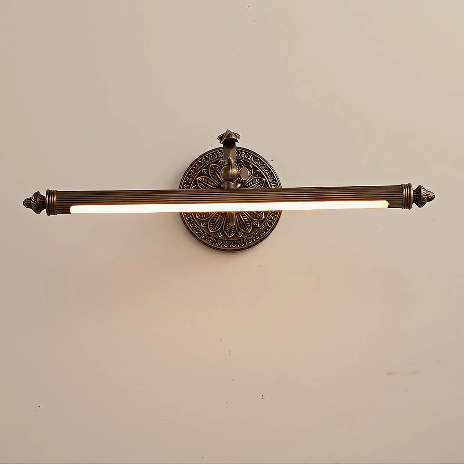 Wide ellesmere brass wall sconce positioned above vanity mirror with warm integrated LED lighting