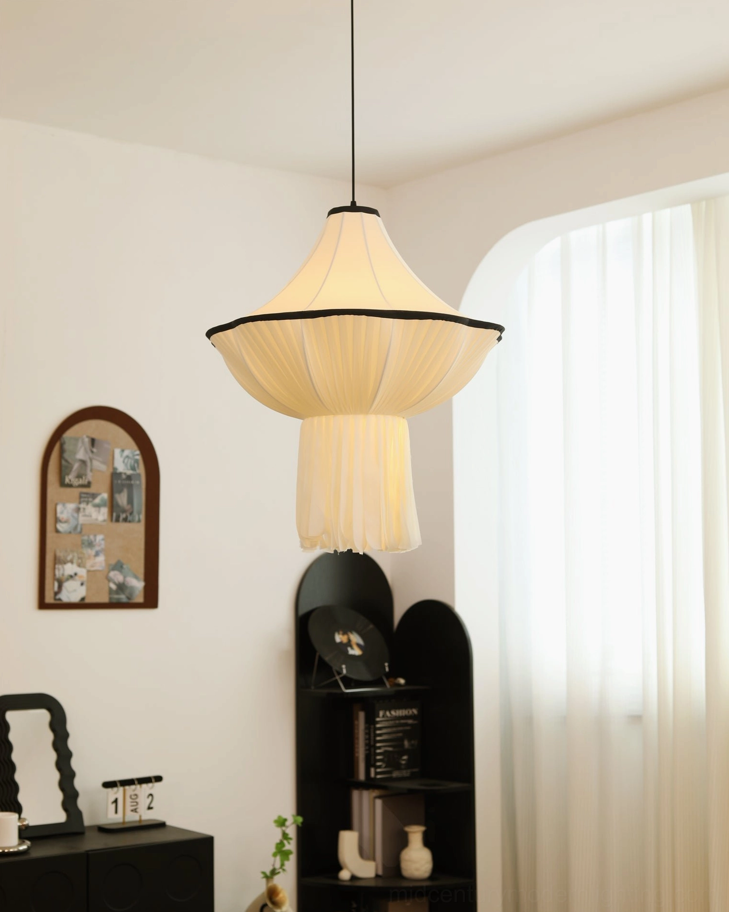 Wildon sculptural pendant light with layered pleated fabric shade, photographed in bright room with sheer curtains
