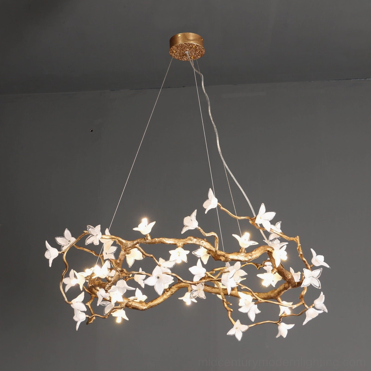 Willow Flower Chandelier installed in interior space with warm LED lighting illuminating glass petals and twisted brass framework