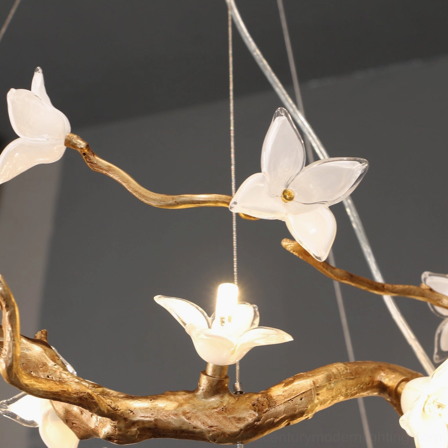 Willow Flower Chandelier close-up detail of clear hand-blown glass petals with warm LED bulb illumination and gold branch texture
