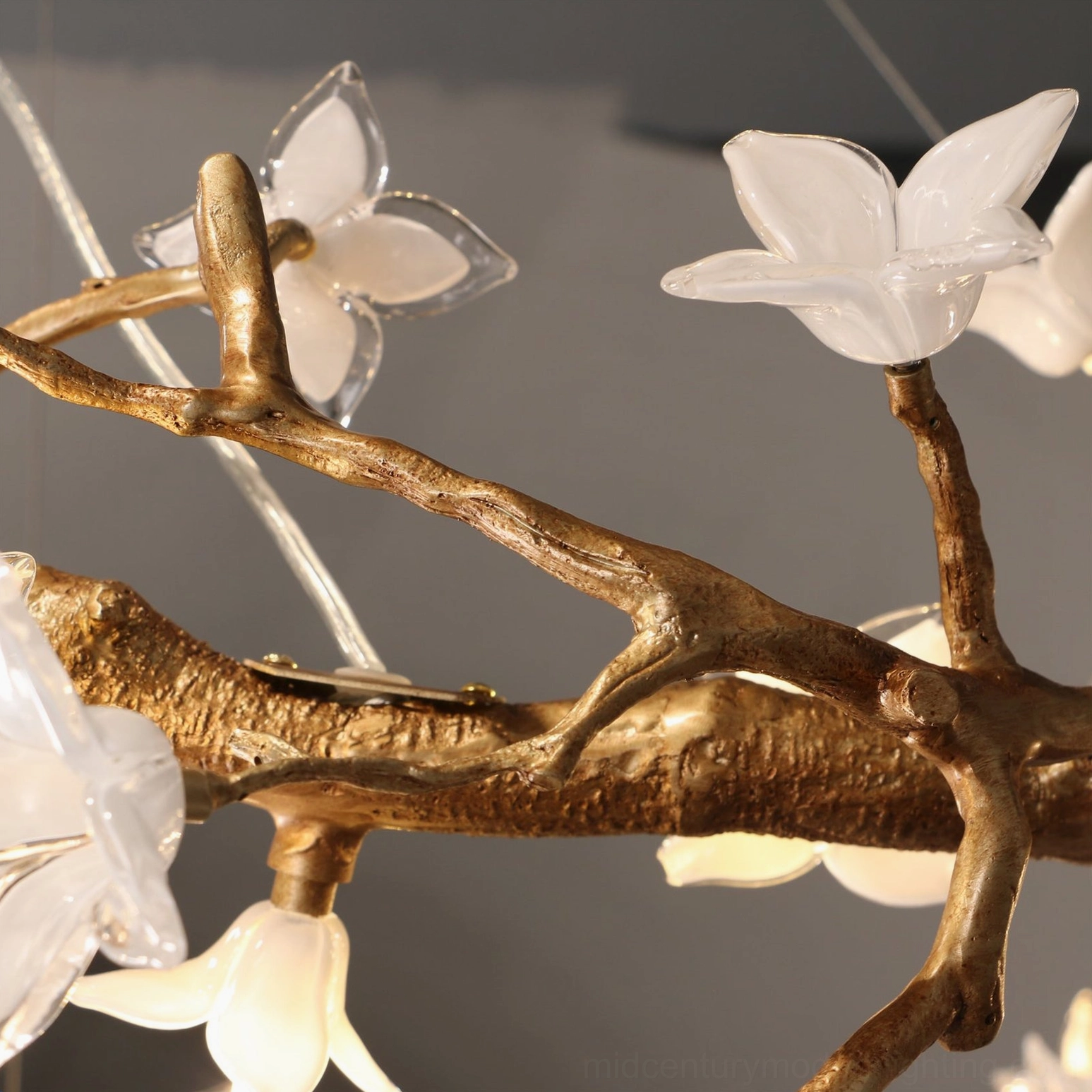 Willow Flower Chandelier accent close-up showing semi-transparent hand-blown glass flowers and matte gold brass framework detail