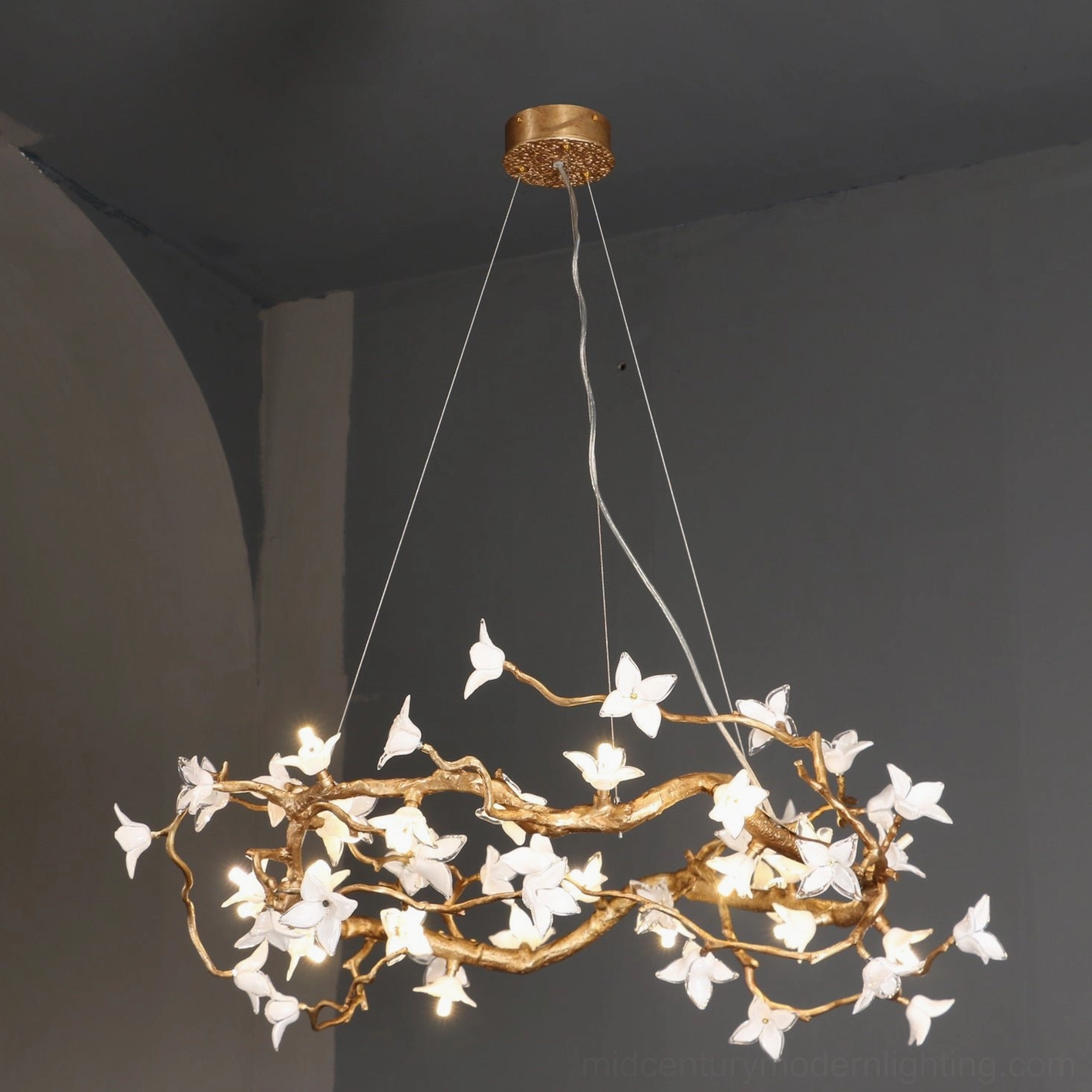 Willow Flower Chandelier three-quarter side view displaying matte gold finish and delicate glass flower clusters against arched wall