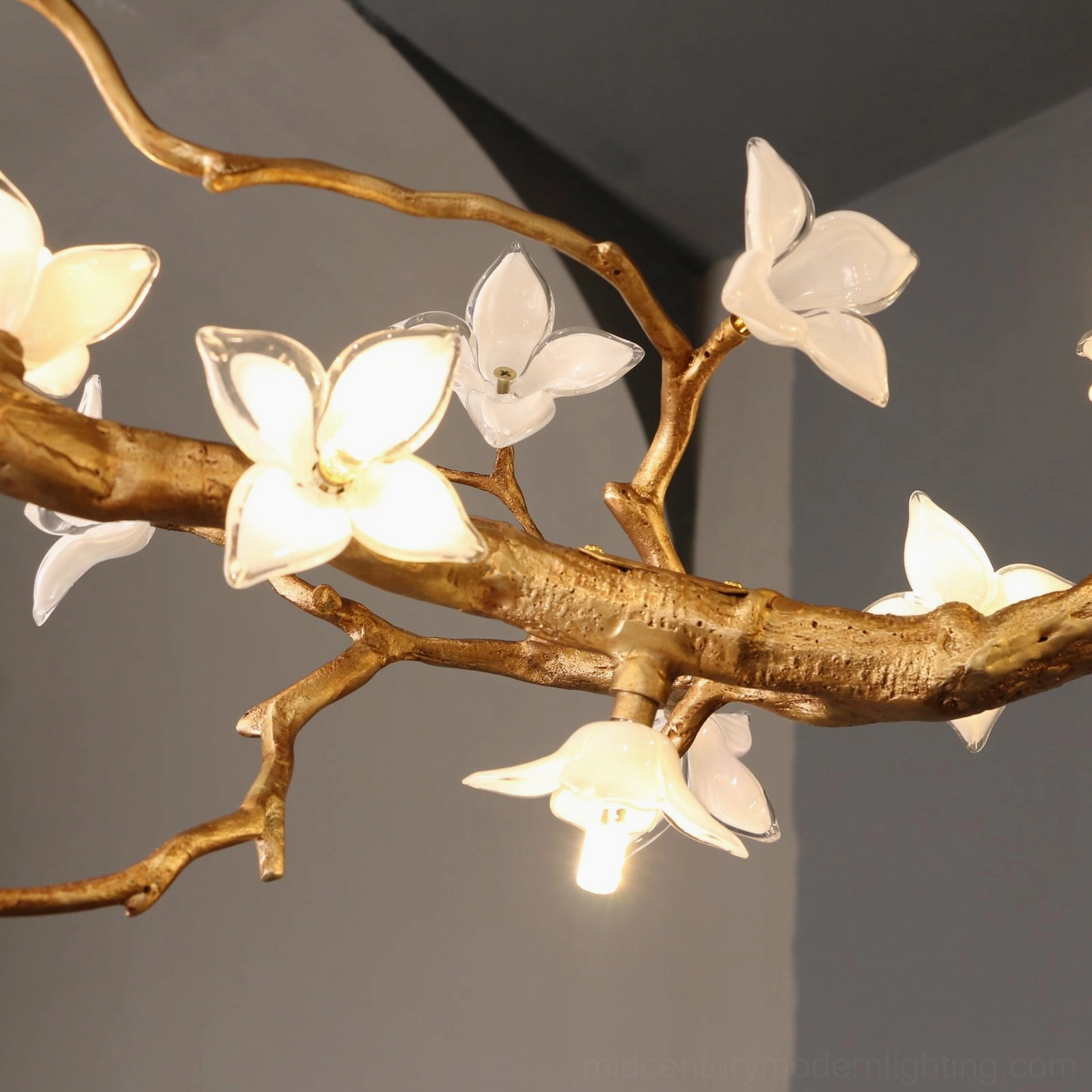 Single Willow Flower Chandelier glass bloom unit close-up with lit bulb and smooth matte gold brass branch texture