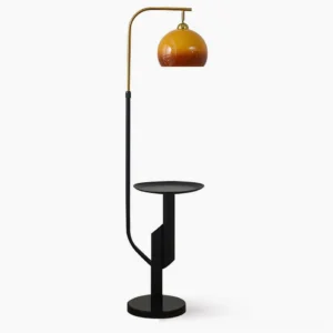 Winona arc floor lamp with integrated side table, front view in studio setting with black metal frame and caramel glass dome
