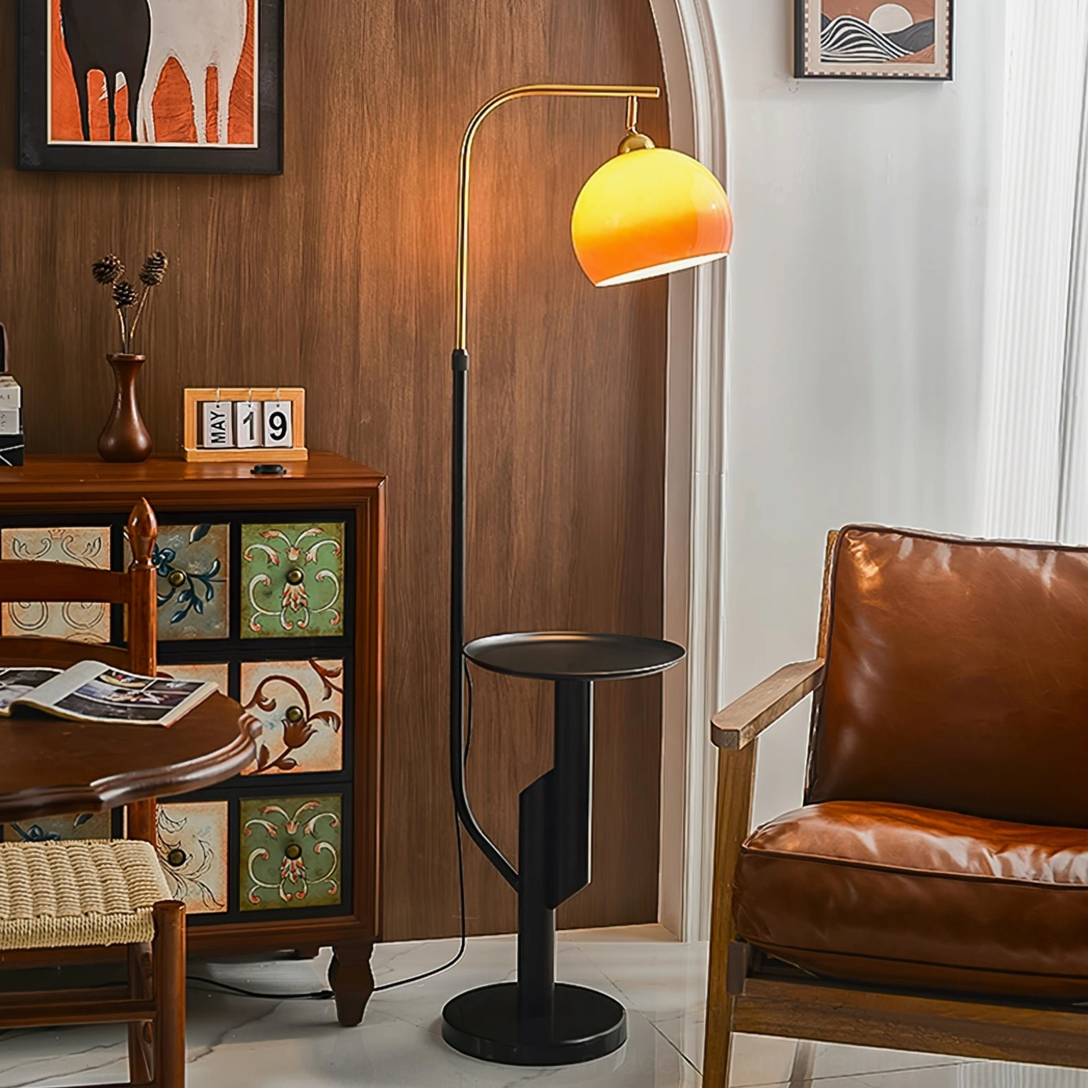 Winona arc floor lamp styled in mid-century modern living room next to leather armchair and wood accents