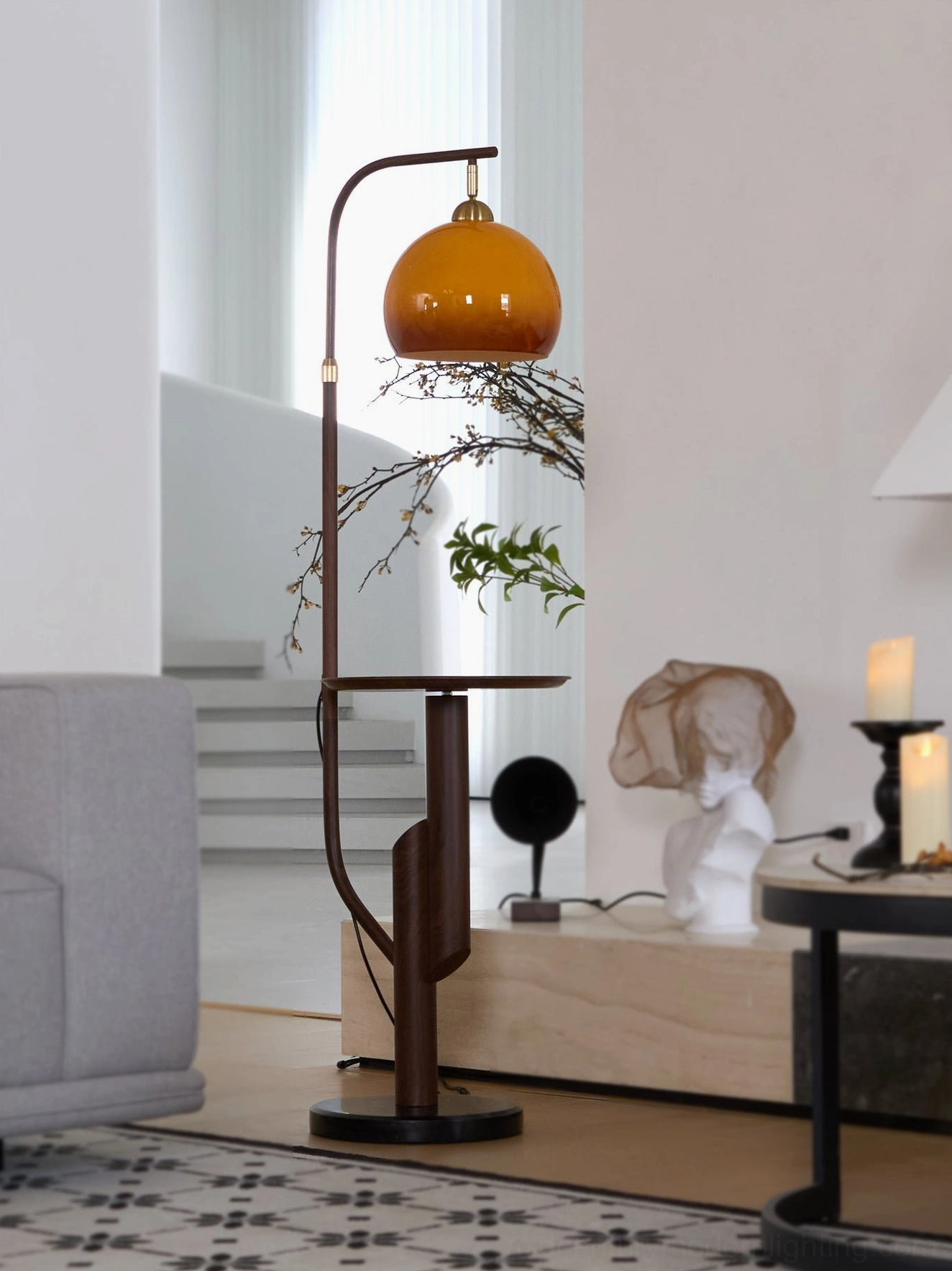 Winona arc floor lamp in modern minimalist living room with green plants and staircase background