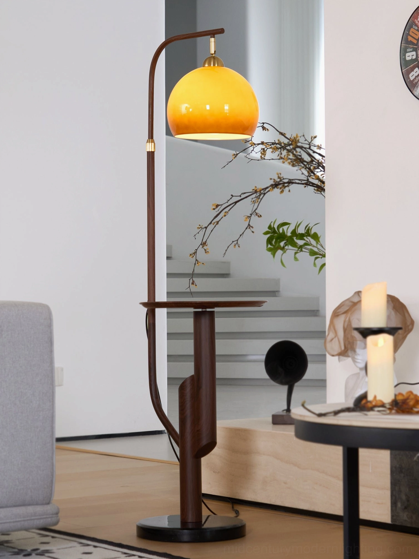 Winona arc floor lamp with side table three-quarter view showing brass arm, glass dome, and round table surface
