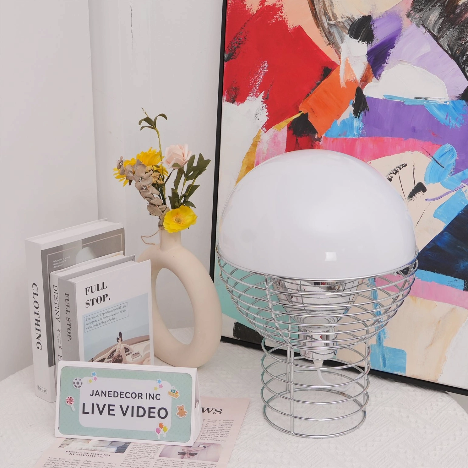 Modern wire cage table lamp styled on home decor table with three-quarter view showing geometric metal frame