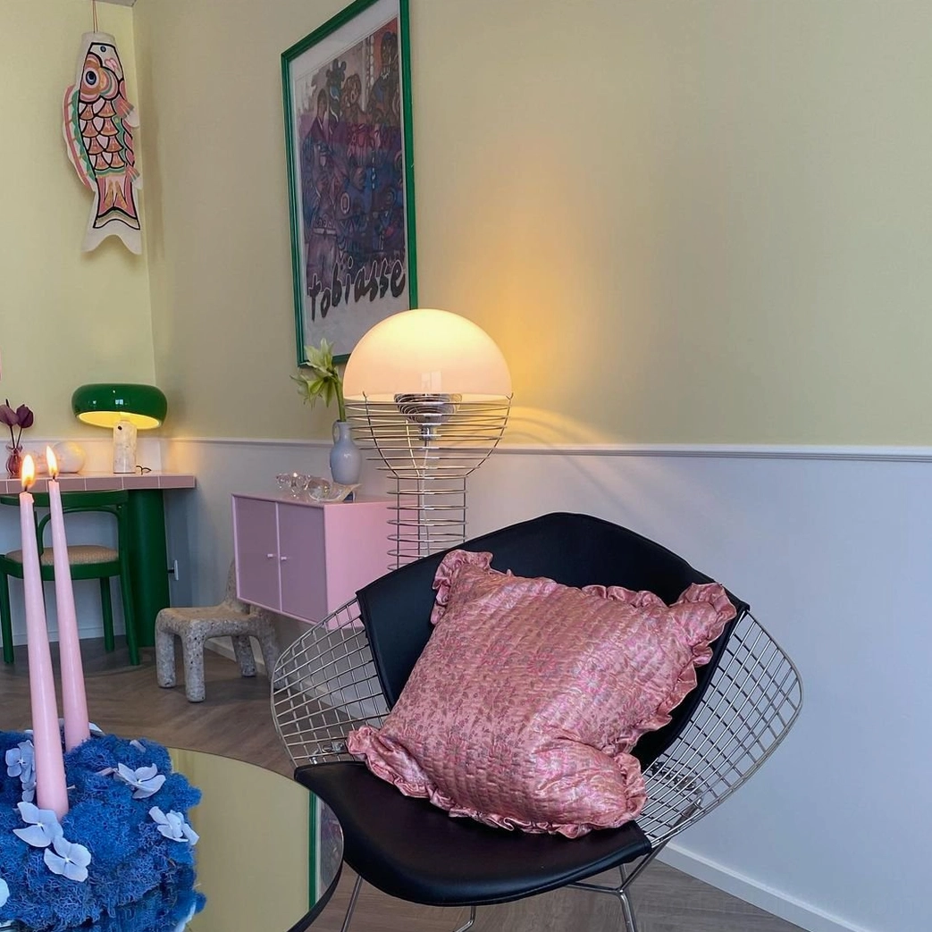 Wire floor lamp with spherical white shade providing ambient lighting in contemporary living space