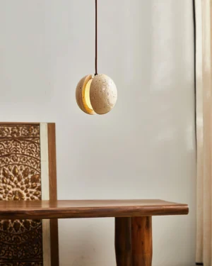 Wisteria pendant lamp illuminated above wooden dining table with carved mid-century chair, warm ambient lighting, interior dining scene