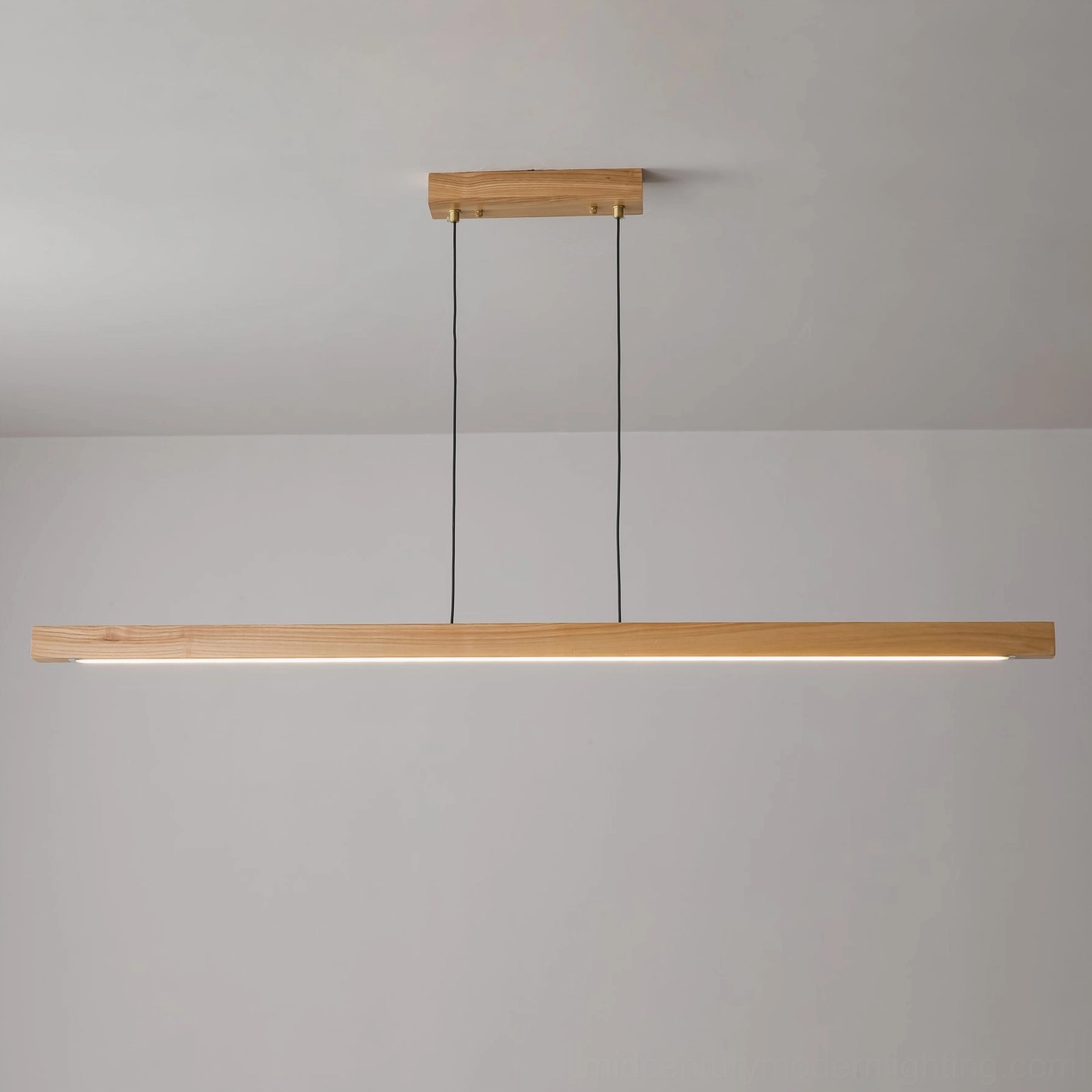 Linear wood LED pendant light showing seamless wood-to-brass transition and suspension mechanism