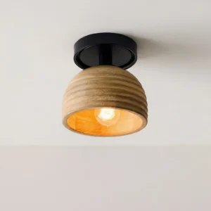 Flush mount wood ceiling lamp overhead close-up view with lit warm-toned bulb, showing illuminated interior light diffusion