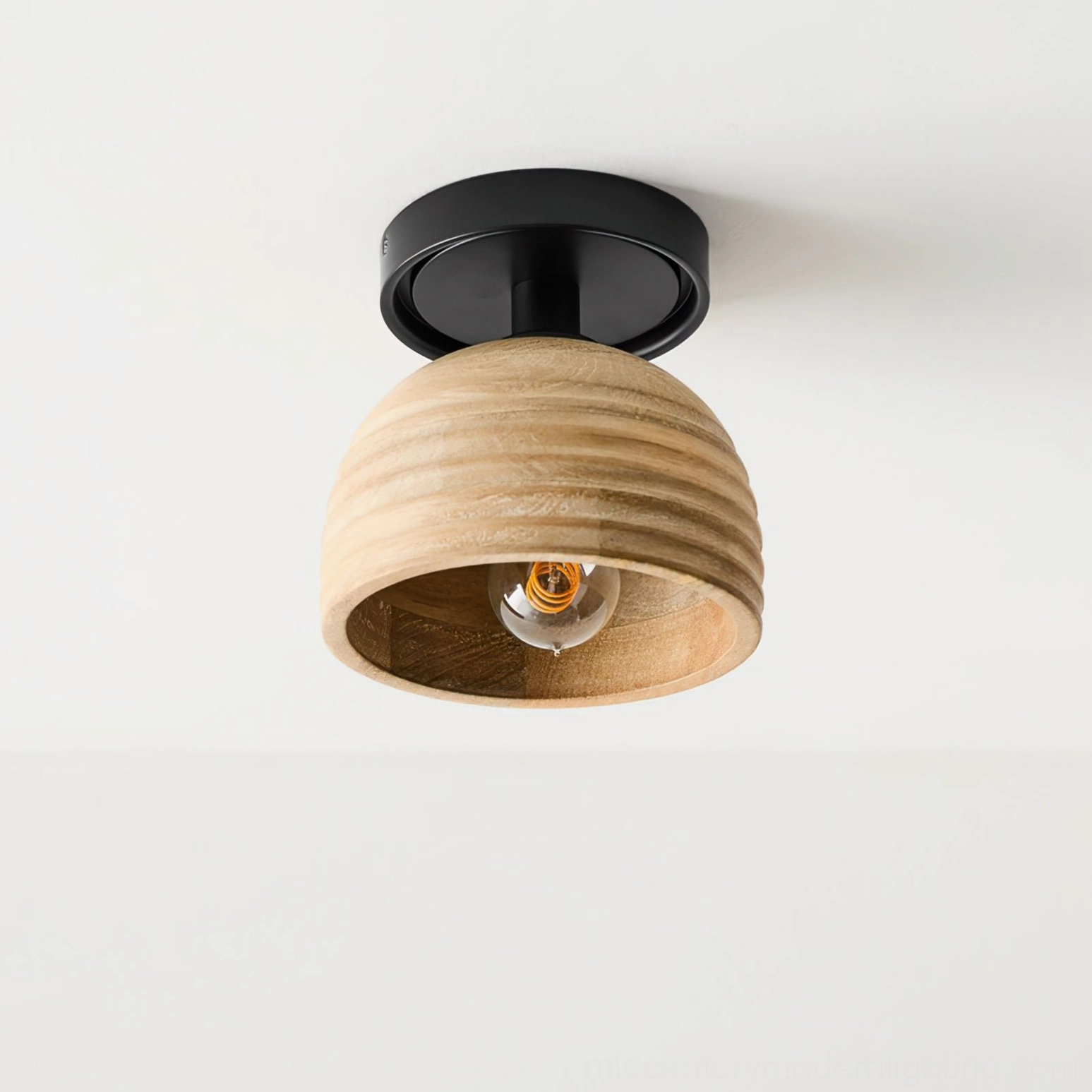 Ribbed wood ceiling lamp side close-up view showing exposed internal spiral bulb and matte black metal frame against white wall