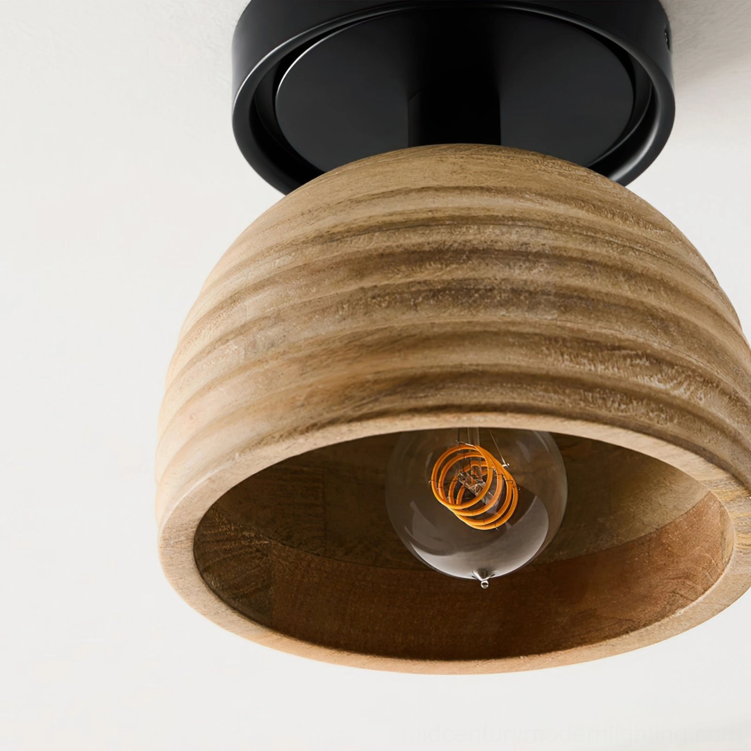 Close-up front view of sculptural wood ceiling lamp featuring spiral filament bulb and layered vertical ribbed wood texture detail