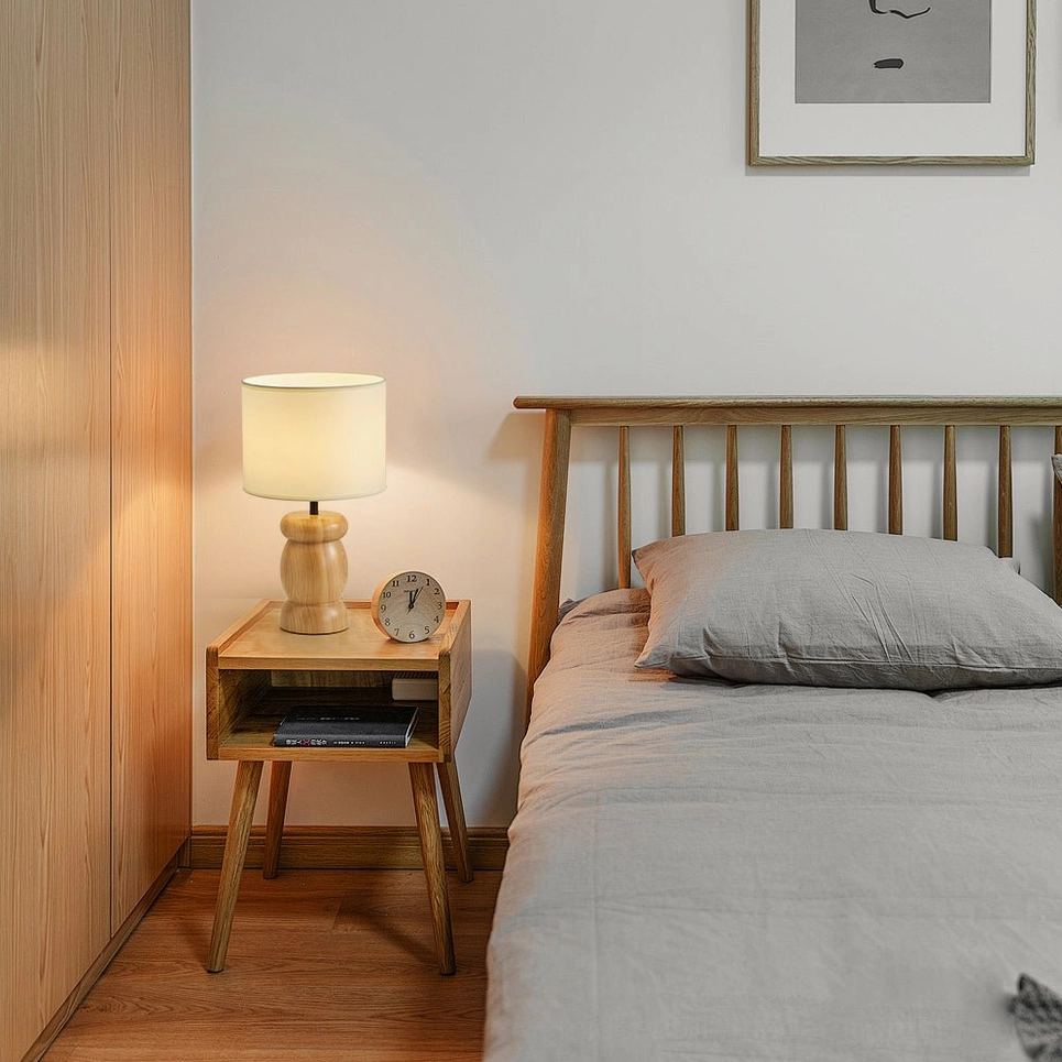 Pebble wood table lamp detail shot, natural wood grain texture, fabric shade weave, mid-century modern craftsmanship