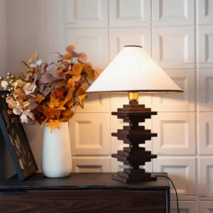 Stacked wood tower lamp styled on bedroom dresser with white dried flowers and minimalist wall decor