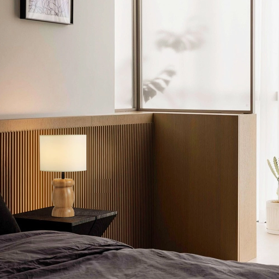 Wooden bedside table lamp with soft fabric shade, warm ambient lighting for bedroom, eye-level side view detail