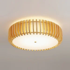 Illuminated natural wood slat drum ceiling light casting warm ambient glow with frosted acrylic diffuser detail