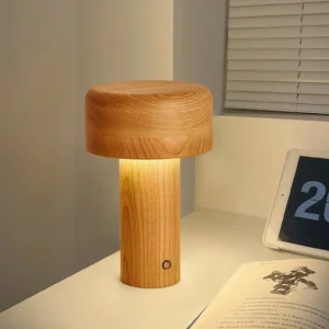 Minimalist wooden table lamp glowing warmly on bedroom bedside table next to book and tablet
