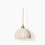 Woven ceramic pendant light with hollow lattice dome shade, white off-white color, brass ceiling hardware, front studio view