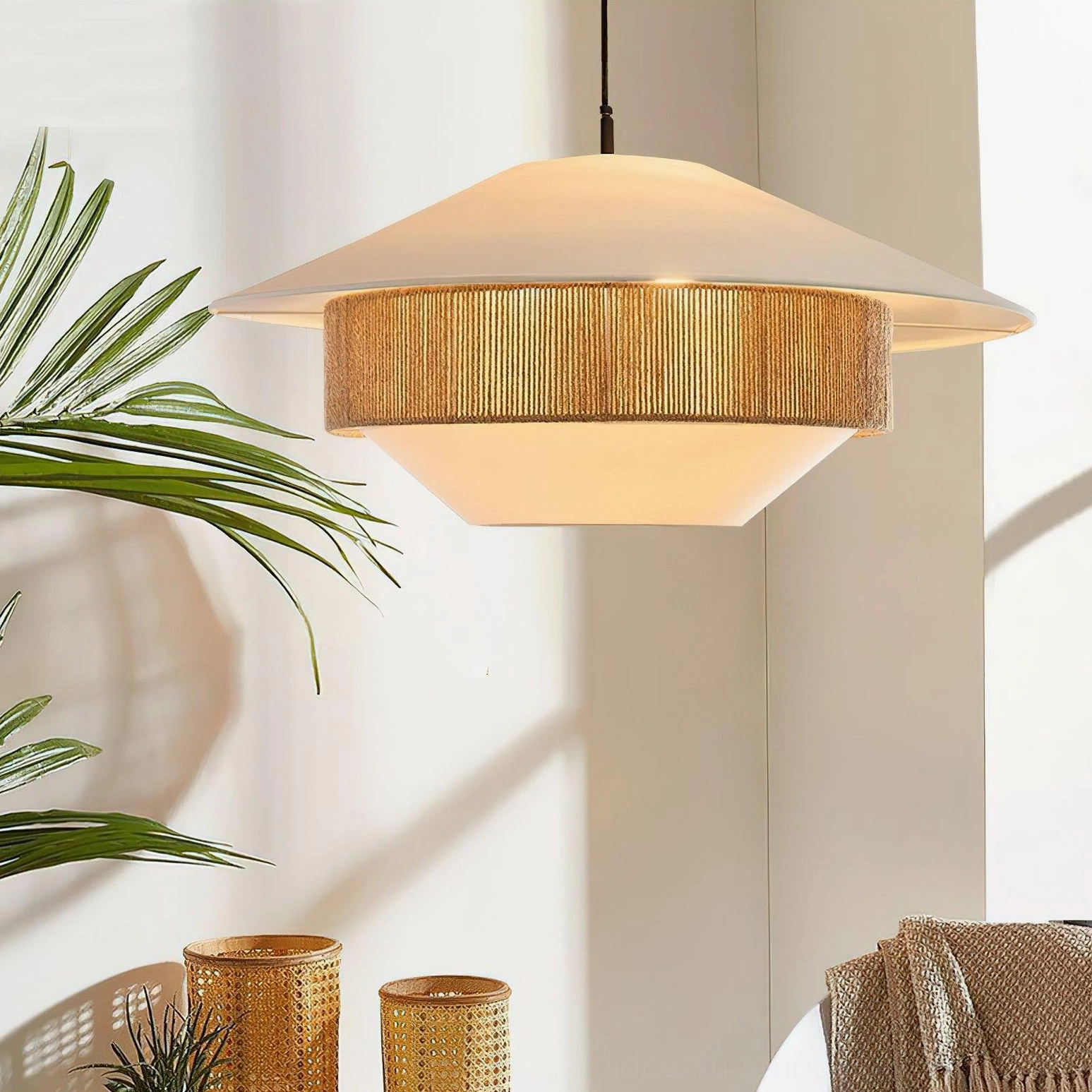 Woven pendant light hanging in indoor corner with tropical plants and bohemian décor, showing rattan detail