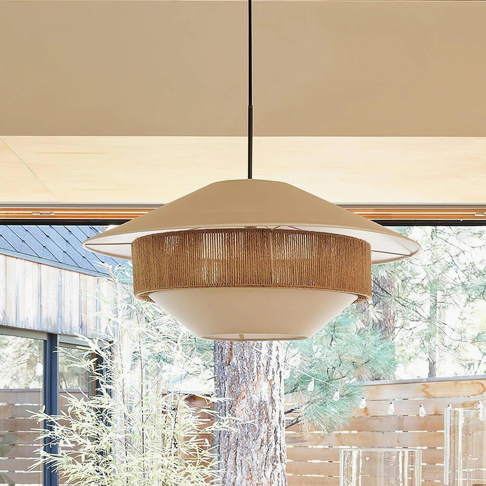White and natural rattan pendant light in dining area overlooking wooden yard, side profile view