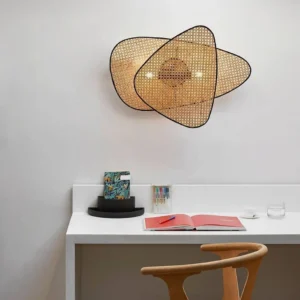 Mid-century modern rattan wall lamp installed on white wall showing dual-panel cannage design and warm ambient light