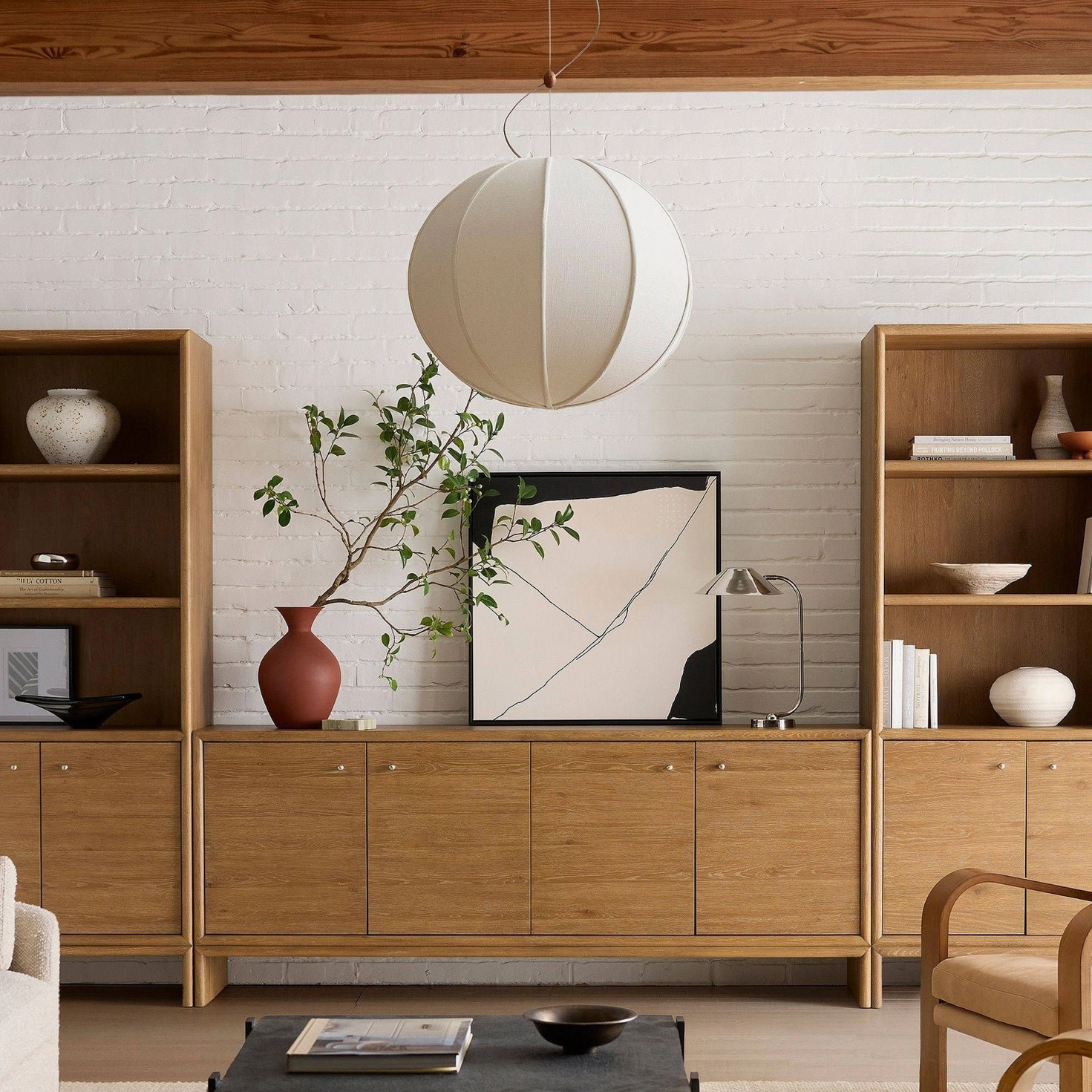 Off-white spherical Yaratam pendant light with smooth matte fabric panels in contemporary interior