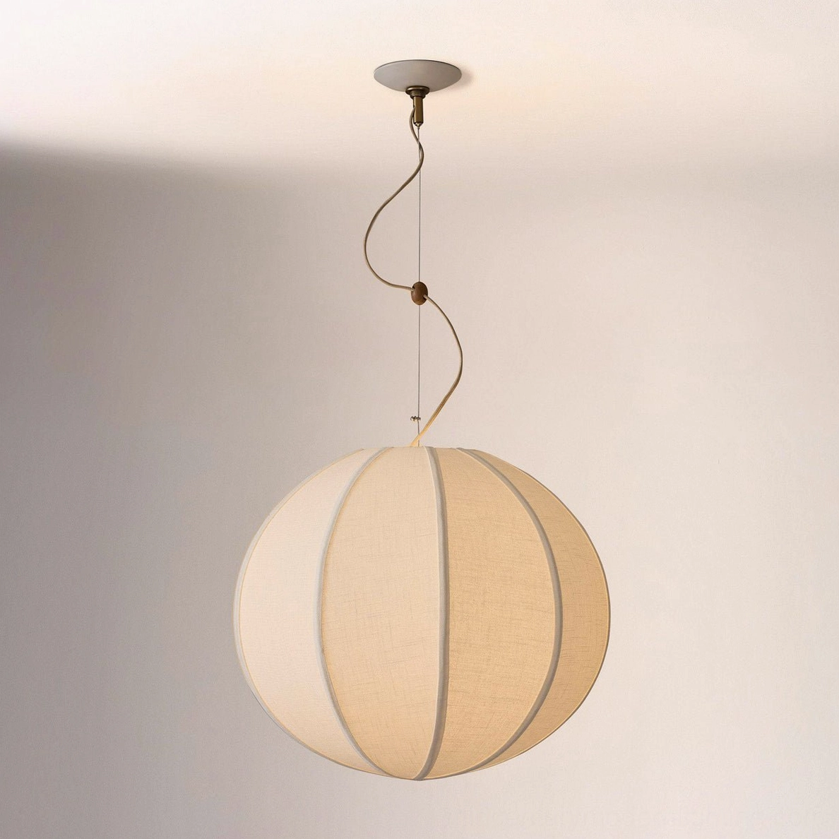 Warm beige Yaratam spherical pendant with twisted metal hardware in studio lighting