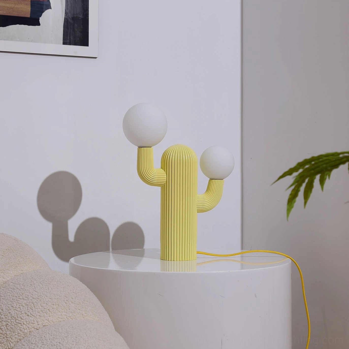 Yellow cactus table lamp with unlit white bulbs, ribbed body design on minimalist display with soft shadows