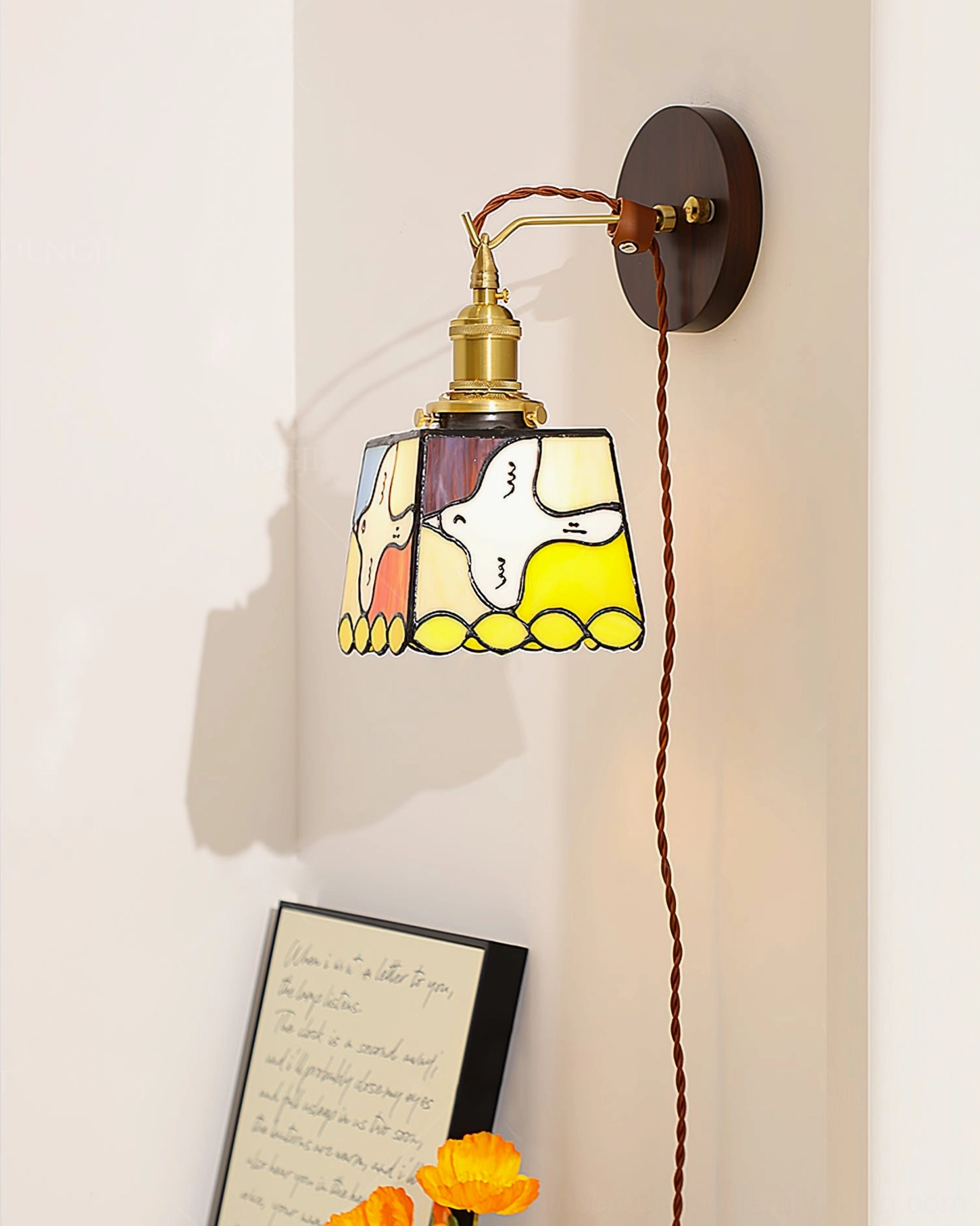 Yellow-toned stained glass dove lamp with vintage brass hardware displayed on interior wall with framed art