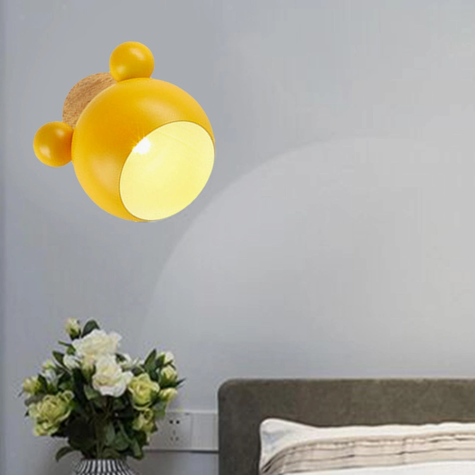 Yellow mouse wall lamp glowing in contemporary bedroom creating warm ambient lighting