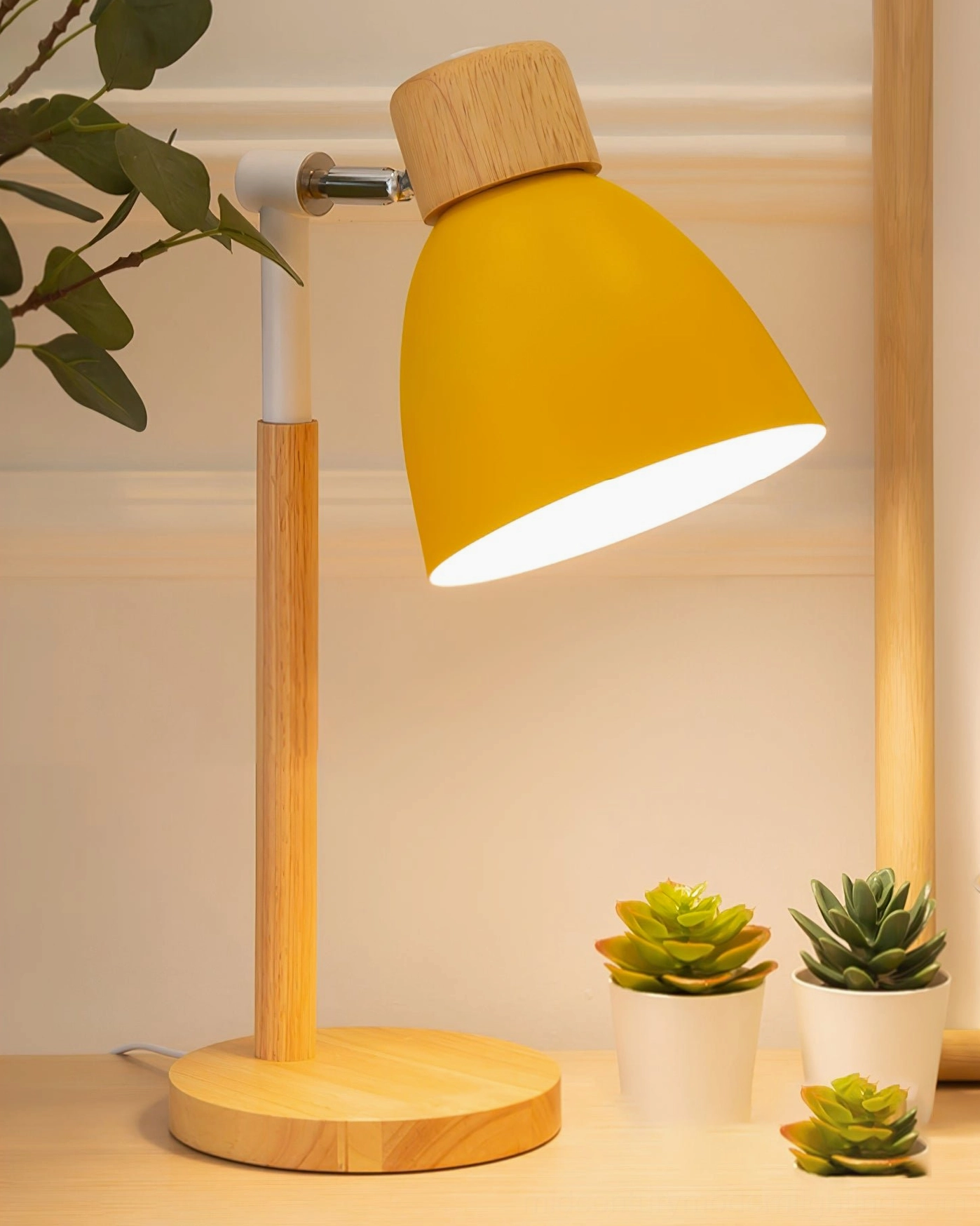 Yellow shade wood table lamp three-quarter side view on tabletop with succulent plants, Nordic home décor styling