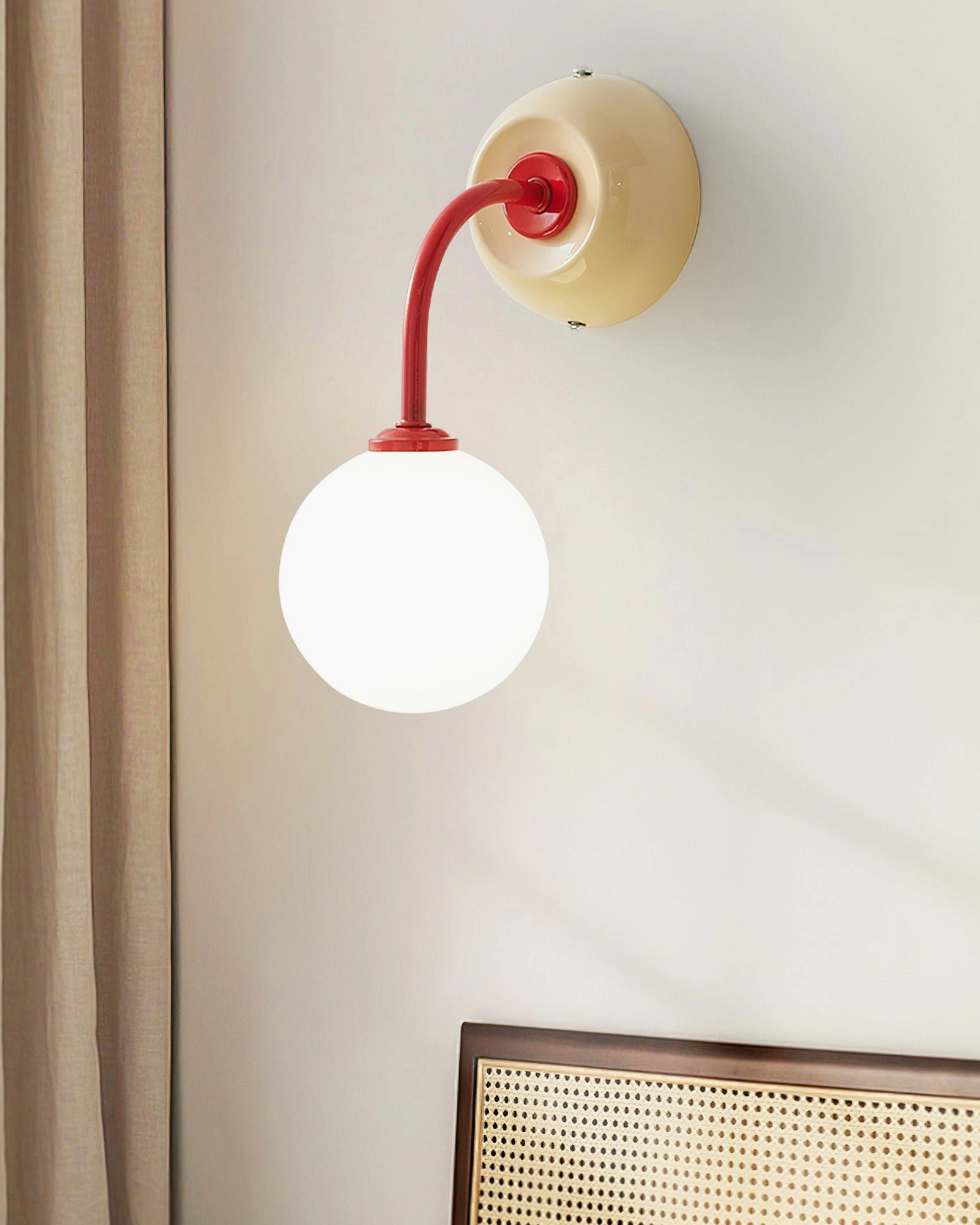 Contemporary Zesta wall sconce mounted in bedroom with rattan headboard, neutral warm tone lighting fixture integrated with natural wood décor