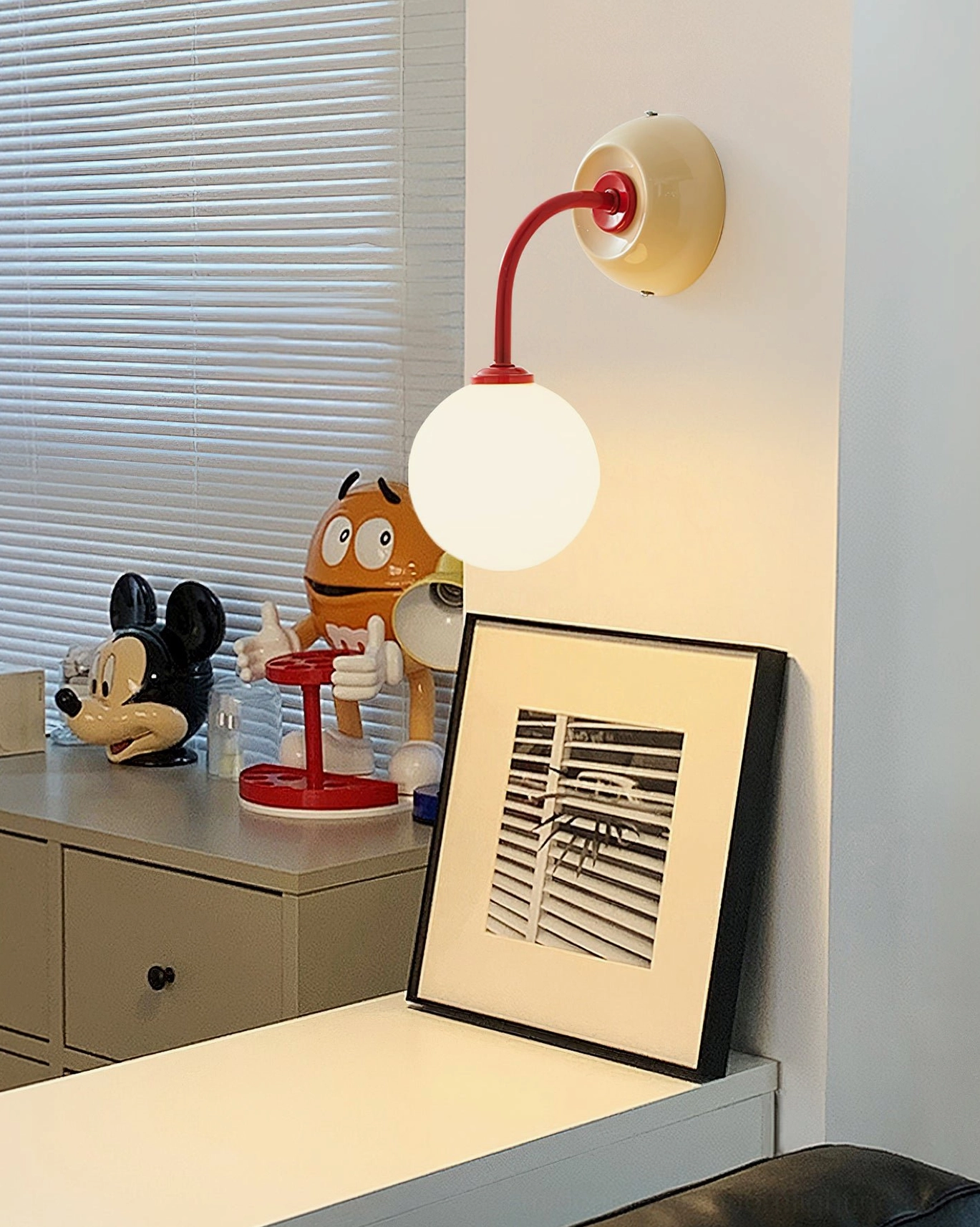 Playful Zesta wall lamp in home vanity area surrounded by colorful cartoon figurines, demonstrating dopamine décor aesthetic with kid-friendly space