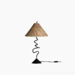 Zigzag rattan table lamp with black metal base front view on white studio background